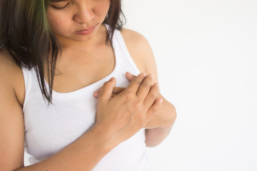 Woman with her hands over one breast
