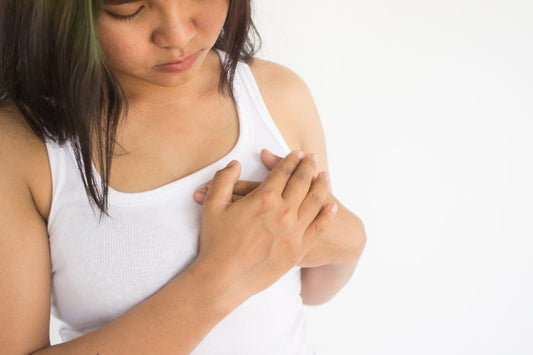 Woman with her hands over one breast