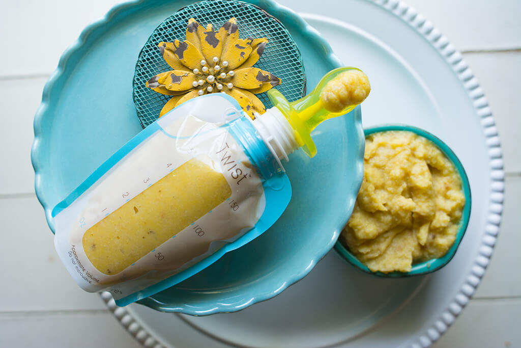Image of a Kiinde Breastmilk Storage Pouch fulled with Cauliflower and Acorn Squash Puree next to a small bowl filled with more puree