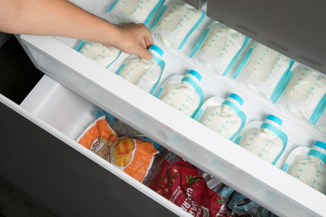 An image of someone grabbing Kiinde breast milk pouches from a freezer